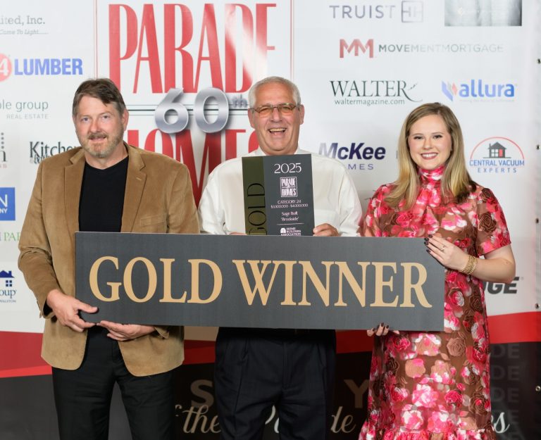 2 men and 1 women holding up a gold winner sign for parade of homes